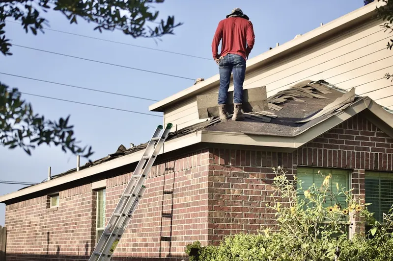 Professional roofer working on a residential roof in Montchan